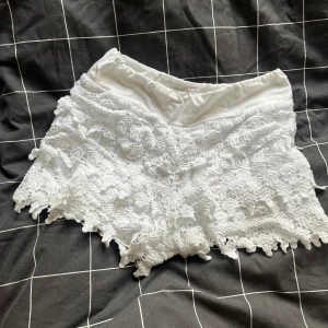 Vita spets shorts  - Superfina vita shorts med spets och volangdetaljer. De har elastisk midja och är fodrade för extra komfort. Perfekta för sommardagar när du vill ha en söt och luftig look. Spetsen ger shortsen en romantisk vibe och de är riktigt lätta att matcha. Står ingen storlek men skulle tippa på xs/s🤗