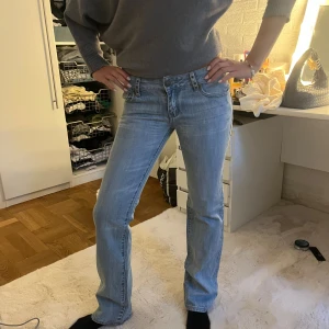 Ljusblå jeans från Bonny Star - Snygga ljusblå jeans från Bonny Star med raka ben och cool broderad detalj på bakfickan. Klassisk femficksmodell med unika knappar och mönstrat innerfoder i midjan. Perfekta för dig som gillar en avslappnad men stilren look.