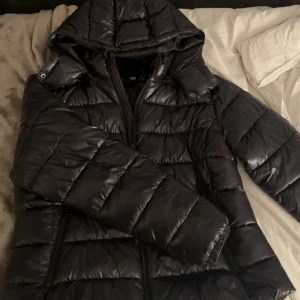 Svart pufferjacka med huva - Använd få gånger. Jätte varm och perfekt till vintern.