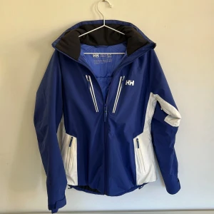 Blå Helly Hansen jacka  - Blåa jacka från Helly Hansen. Bra skick. Varm och skön jacka. Nypris 2500 kr. 
