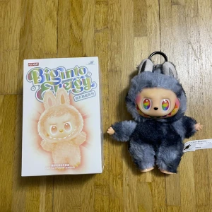 Pop Mart Biginto Energy Giant Plush Pendant Blind Box - Pop Mart Biginto Energy Giant Plush Pendant, komplett med originalförpackning. Mjuk och söt samlarfigur i utmärkt skick, perfekt som dekoration eller present. Inga synliga defekter eller slitage. Passar samlare och fans av Pop Mart.
