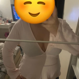 Ljusrosa omlottopp med v-ringning - Säljer en ljusrosa omlottopp med djup v-ringning och långa ärmar. Toppen har en feminin och avslappnad passform, perfekt för dig som gillar en enkel men snygg stil. Materialet känns mjukt och lätt mot huden.