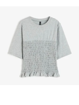 Grå topp med smock från H&M Divided - Säljer en ljusgrå topp från H&M Divided i storlek S. Toppen har smockad midja och volangkant nedtill, samt halvlånga ärmar och rund halsringning. Tillverkad i mjuk bomull som känns skön mot huden. Perfekt till jeans eller kjol för en chill look. Använd ca 3 ggr🩷