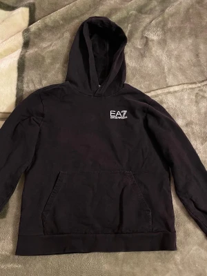 EA7 Armani Hoodie strl xs - Säljer en Svart hoodie från Emporio Armani i storlek XS som jag köpte för ungefär 1 och ett halvt år sedan säljer på grund av att den inte passar mig längre 