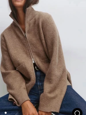 Beige kofta med dragkedja - Slutsåld på Gina!!! Nypris 499kr Aldrig använd pga för stor😊Mysig beige kofta i ullmix med hög krage och dragkedja framtill. Modellen är loose fit med långa ärmar och ribbade muddar. Perfekt att slänga på sig över en t-shirt för en chill look.