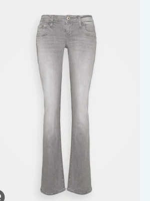 Grå bootcut jeans med låg midja från LTB - Säljer ett par snygga grå jeans med bootcut-modell och låg midja. Jeansen har klassisk femficksdesign, knapp och dragkedja framtill samt en lätt tvättad look. Perfekta för dig som gillar en avslappnad men trendig stil. Använda fåtal gånger, skriv för fler frågor! 