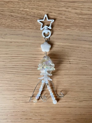 Svart manet-nyckelring med pärlor  🪼🤍 - 🤍En manet som kan följa med på din resa! ⋅˚₊‧ ଳ⋆.ೃ࿔*:･  Maneten har glas komponenter så var försiktig! <3  Skriv i DM först, tack! ༊彡