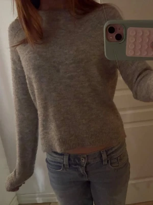 Grå stickad tröja - ‼️PRIS KAN DISKUTERAS‼️ Mysig ljusgrå stickad tröja med rund hals och långa ärmar. Tröjan har en lite croppad passform och ribbade muddar vid ärmslut och nederkant. Lite nopprig.  Tröjan är jättemysig och superskönt🤗