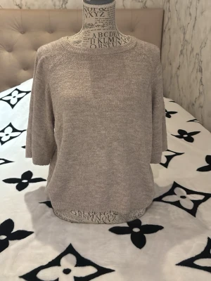 Beige stickad tröja med trekvartsärm - Mysig beige stickad tröja med rund halsringning och trekvartsärmar. Perfekt för lager-på-lager och passar till både jeans och kjol. Enkel och stilren design som funkar året runt.