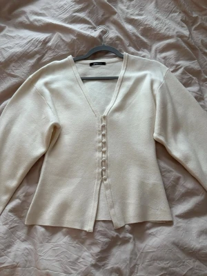 Beige kofta med knappar från Gina Tricot - Beige tröja från Ginatricot i storlek S. Använd 1 gång, som ny.