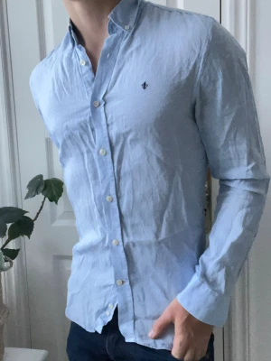 Morris Linen skjorta.   - GRATIS VID KÖP ÖVER 500 kr. Morris 100% line tröja, ljusblå. Väldigt trevlig skjorta. Modellen är 180 cm 75 kg storlek S. Relativt missfärgad under armhålorna 