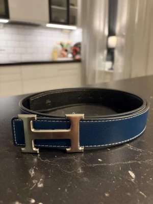 Blått H-bälte - Säjer ett blått H-bälte. 110 cm långt men finns möjlighet till att göra hål. Bältet ger en riktigt stilig och erfaren look. Perfekt för dig som söker något elegant i vardagen. Vid frågor är det bara o höra av sig👍☺️