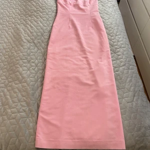 Ljusrosa axelbandslös långklänning - Säljer en elegant ljusrosa axelbandslös långklänning med figurnära passform. Klänningen har en slät yta och är helfodrad. Perfekt för dig som vill ha en stilren och feminin look.passar xs-m stretch kan även passa L är osäker. Hämtas i norsborg botkyrka eller fraktas. Säljer över 30 klänningar skicka pm 