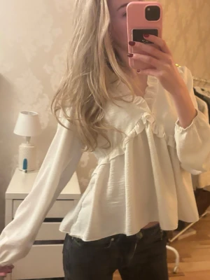 Blus - Denna vita blusen har väldigt fina detaljer men ändå väldigt enkel och fin både vanliga dagar och under fina stunder. Den sitter väldigt fritt samtidigt som den framhäver ändå din siluett på ett elegant sätt💕 Den är osized, då den är fri passar den fler storlekar, ungefär S/M