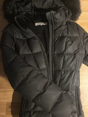 Svart pufferjacka från Calvin Klein - Säljer en svart pufferjacka från Calvin Klein. Har många bra fickor även innvändigt. 