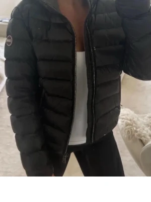 Colmar jacka - Säljer en svart pufferjacka från Colmar. Jackan har huva och perfekt för kyliga dagar. Använd men Fof mycket bra skick! ( lånad bilder men samma jacka och skick )