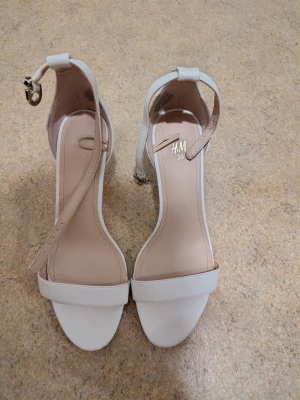 Vita klackar från H&M i storlek 38 - Vita klackar från H&M i storlek 38, använda en gång under en middag. Köpta för flera år sedan, originalpris runt 300 kronor. Hämta/lämna helst i Stockholm city/solna.