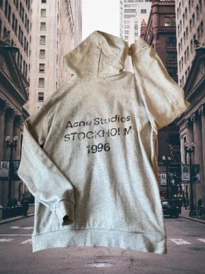 Acne Studios hoodie  - Snygg grå hoodie från Acne Studios med tryck på ryggen: 'Acne Studios STOCKHOLM 1996'. Storlek M men fungerar även för L beroende på vilken passform man vill ha. Skriv vid frågor