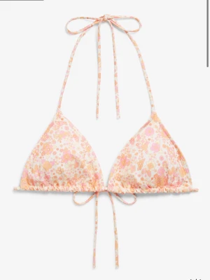 Supergullig bikini med blommönster  - Söt bikini med trekantsöverdel och knytband i nacken och ryggen. Mönstret är blommigt i ljusa pastellfärger som rosa, orange och vitt. Matchande bikinitrosa. Överdelen i storlek xs och nederdelen s, aldrig andvända och nypris 350 för båda☺️💕🌸slutsåld på hemsidan