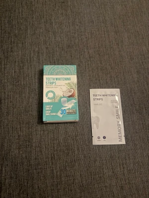 Teeth Whitening Strips Memory Smile - Teeth Whitening Strips från Memory Smile med naturlig kokosolja. Förpackningen är turkos och vit med detaljer i silver och brunt. Stripsen ger kritvita tänder på 30 minuter och är enkla att använda. Perfekt för dig som vill ha ett fräschare leende jättesnabbt.