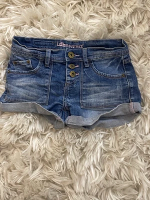 Blå jeansshorts från Lab Industries - Snygga lågmidjade unika jeans shorts! Jag säljer dessa pga av att det i passar så bra på mig! Pris kan diskuteras