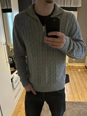 Kabelstickad Halfzip  - Säljer då den endast använd 1-2 gånger, storlek M, men passar både L och M beroende på hur löst/tight man vill att de ska sitta. Tröjan är från Selected Homme. Ljusgrå i färgen och nypris 699. Bara att höra av sig vid frågor! 