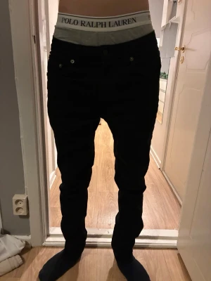 Svarta jeans  - Säljer ett par svarta jeans med klassisk femficksdesign. Jeansen har en stilren look och lite stretch för extra komfort. Perfekta för dig som gillar en clean och enkel stil.