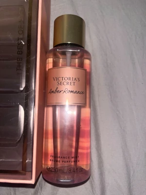 Victoria's Secret Amber Romance mist - Amber Romance från Victoria's Secret är en body mist med varm bärnstensdoft och sötma. Flaskan är genomskinlig med persikofärgad etikett och guldfärgat lock. Innehåller 250 ml och har en elegant, feminin design som känns lyxig och modern.