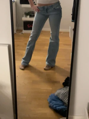 Ljusblå bootcut jeans - Säljer ett par ljusblå bootcut jeans med låg midja. Klassisk femficksmodell i mjukt denimtyg och snygg passform som ger en avslappnad vibe. Perfekta till sneakers eller boots.
