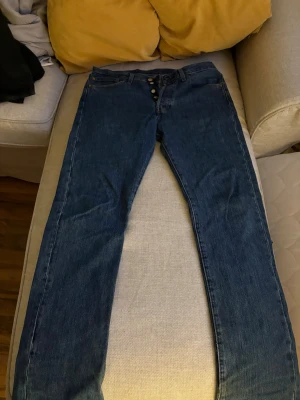 Levi's 501 mörkblå jeans straight fit - Klassiska vintage mörkblå Levi's 501 jeans med rak passform och knappgylf. Jeansen är tillverkade i slitstark bomullsdenim. W 32 L 32. Skicka bud:)