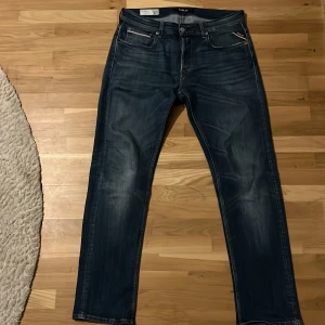 Replay blå raka jeans storlek w30 L32 - Säljer ett par klassiska blå jeans från Replay med raka ben och snygga slitningar. Jeansen har fem fickor, normal midja och är tillverkade i ett slitstarkt denimtyg. Perfekta för dig som gillar en tidlös och avslappnad stil.