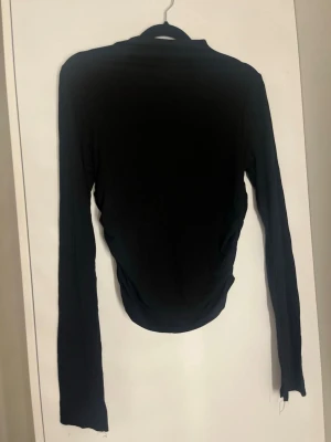 Svart långärmad topp med slits - Super fin långärmad topp från gina i strl M 💕 Anvönts en gång och nu passar den ej. 