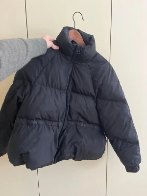 Svart pufferjacka Ganni - Säljer en svart pufferjacka med hög krage från Ganni. Jackan har en oversized passform. Se defekter på bilderna. Den har blivit lagad i fickorna. Kan bli fin i kemtvätt 😊