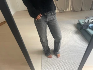 Grå raka jeans - Säljer ett par grå jeans med rak passform . Jeansen har klassisk femficksdesign och är tillverkade i denim. Perfekta för en avslappnad och trendig look.
