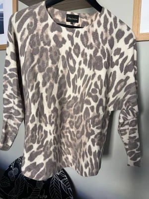 Beige leopardmönstrad tröja - Snygg beige tröja med leopardmönster från Chica London. Tröjan har rund halsringning och långa ärmar. Materialet ser mjukt och bekvämt ut, perfekt för dig som gillar djurmönstrat och vill sticka ut lite extra.