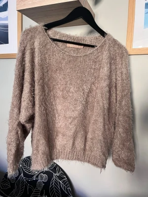 Beige fluffig stickad tröja MARTA - Supermjuk och fluffig beige stickad tröja från MARTA. Tröjan har en lös passform, rund halsringning och långa ärmar. Perfekt för dig som gillar en cozy och avslappnad stil. Materialet är lurvigt och ger en riktigt mysig känsla.