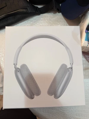 Apple AirPods Max silver hörlurar - Snygga Apple AirPods Max i silver med over-ear design. Hörlurarna har en stilren aluminiumram, meshbygel och mjuka öronkuddar i tyg för extra komfort. Perfekta för musik, film och gaming med grym ljudkvalitet och modern look.