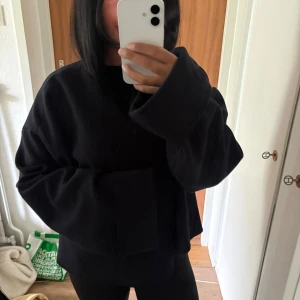 Svart oversized jacka från Gina Tricot - Säljer en svart oversized jacka från Gina Tricot med breda ärmar och avslappnad passform. Perfekt för dig som gillar en enkel men trendig look. Materialet känns mjukt och bekvämt mot huden. Passar till allt och är lätt att styla.