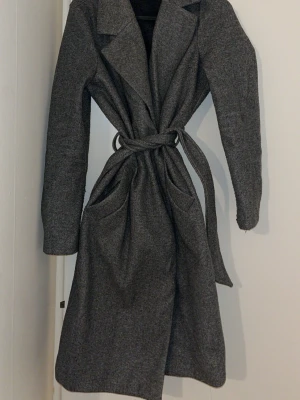 Grå lång kappa  - Grå kappa från Vero Moda med två stora fickor framtill. Perfekt för kyliga dagar 