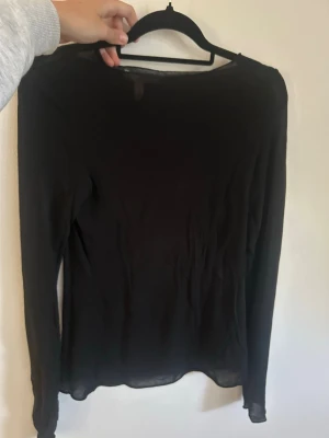 Svart långärmad topp kashmir  - En enkel svart långärmad topp med rund halsringning. Tunn och lätt i materialet, perfekt att styla lager på lager eller bära som den är. Passar till det mesta och är ett måste i garderoben.