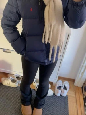 Mörkblå dunjacka från Polo Ralph Lauren - Snygg mörkblå dunjacka från Polo Ralph Lauren med huva och dragkedja framtill. Jackan har två framfickor med dragkedja och den klassiska röda loggan på bröstet. Perfekt för kalla vinterdagar och riktigt skön att bära. Lapparna är inte längre på och den är andvänd ca 5 gånger utan några defekter💕