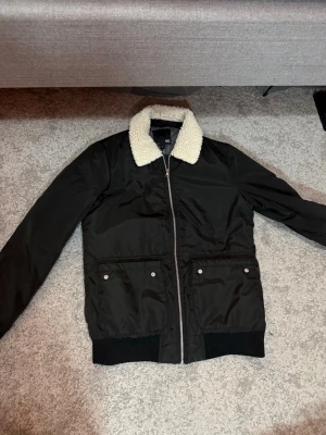 Pilotjacka Svart med Ullkrage - Stilren svart pilotjacka med varm ullkrage från lager157. Klassisk pilotjacka-inspirerad design som passar perfekt till en casual streetwear-look.  Färg: Svart Storlek: S  Fraktar inom 24h vid snabb affär. Byten är inte aktuella.  #Pilotjacka #BomberJacket #SvartJacka #Streetwear #Menswear