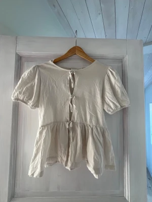 Vit blus med knyt och puffärm - Supersöt vit blus med puffärmar och tre knyt framtill!💕