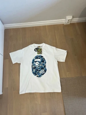 Vit BAPE t-shirt med blå camo-print - Jag säljer min bape tröja för den är för stor för mig 