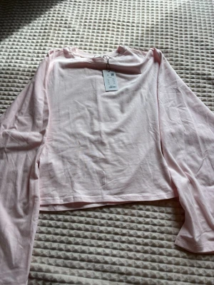 Ljusrosa långärmad topp i bomull - Snygg rosa tröja som är tajt vid midjan och har lite större armar. Passar till mycket och ser snyggt ut med mycket. Helt ny och oanvänd då jag inte gilla hur den satt på mig, men det är inget problem med den 💞