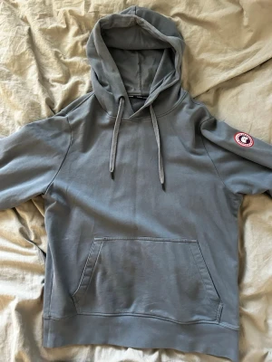 Blå Canada Goose hoodie  - Blå Canada goose hoodie med ett nypris på runt 3000 kr. 