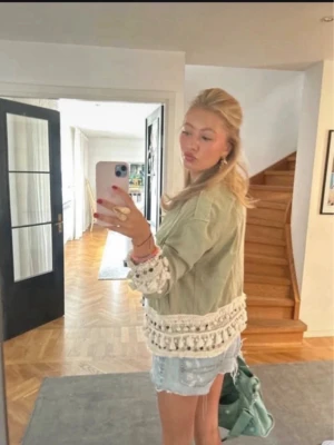 Zara jacka  - Trendig beige overshirt med virkade och broderade detaljer längs ärmslut och nederkant. Jackan har en loose passform och långa ärmar, perfekt att slänga över en topp för en cool look. Finns ej kvar på Zara. 