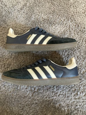 Mörkblåa Adidas Samba sneakers - Jag säljer nu ett par Adidas samba i färgen mörkblå som är storlek 42! Skorna är använda några fåtal gånger.  priset som jag säljer skorna för är endast 699kr! Om du har några frågor så är det bara att skriva! Priset går att diskutera.