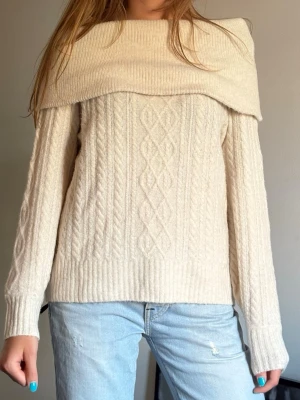 Beige kabelstickad tröja med krage - Jättemysig stickad offshoulder tröja, perfekt till hösten!💕Säljer den då den inte kommer till användning. Den har inga defekter och är i storlek XS men den passar fint på mig som är M!😊