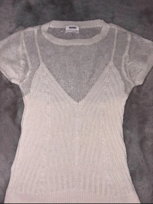 Monki topp cremevit 🤍✨ - Köparen står för frakt. Säljer en fin topp från Monki i storlek M. Modellen ser ut som en t-shirt med ett linne över, vilket ger en trendig och unik look. Perfekt till både jeans, kjol eller shorts.  ✨ Märke: Monki✨ Färg: Cremevit/vit✨ Storlek: M✨ Skick: Bra skick, sparsamt använd.✨ Trendig lager-på-lager-design som är lätt att styla.  Hör gärna av dig om du har frågor eller vill ha fler bilder! 💕